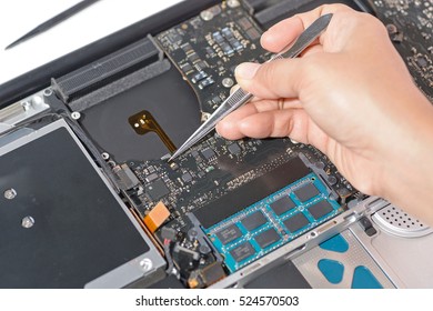 technicial install ribbon cable connection to laptop computer mainboard