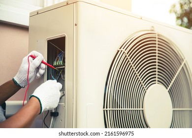 Technician Air Conditioning Repairman Using Measuring Equipment Checking Electrical At Circuit Breaker On Outdoor Air Compressor After Install And Check Refrigerant System Maintenance.