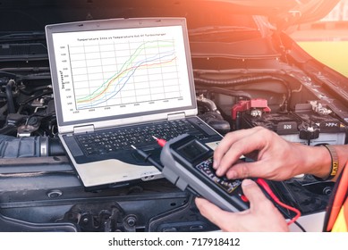 The technician analyze the car's engine graph on laptop computer in the garage. the concept of automotive, repairing, mechanical, vehicle and technology.