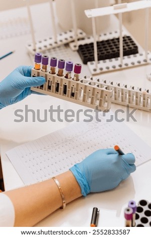Technician analyzing blood samples in a lab with detailed documentation for medical research. High quality photo