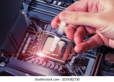 A technician applies white thermal paste to the CPU. Installing a cooler on a PC processor. Assembling or upgrading a Personal Computer