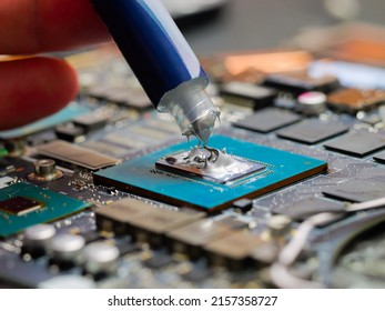 Technician Applying Thermal Paste To A GPU On Laptop Motherboard. Cooling Upgrade Concept. Graphics Processor.