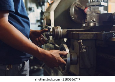 Technician asia worker using turning lathe machine for metalworking in workshop factory - Shutterstock ID 2180286747