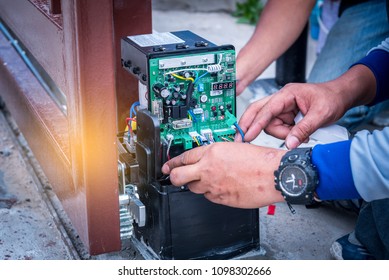 Technician assembling and testing motor automatic gate for home security system.
