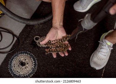 A technician blowdrying a bike chain. Servicing and overhauling a mountain bicycle drivetrain at a Bike repair shop.