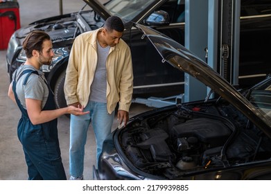 Technician in car service talking to the client - Powered by Shutterstock