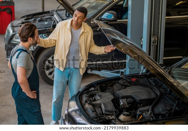 Technician in car\
service talking to the\
client