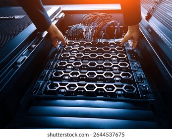 A technician carefully installs server components into a data center rack, showcasing modern technology and hardware management in a professional setting.