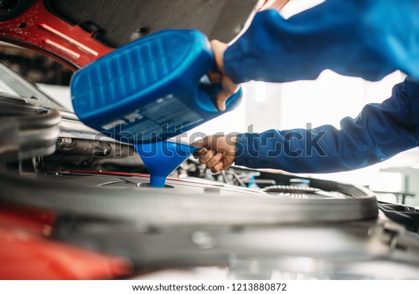 Technician change oil in the\
car engine
