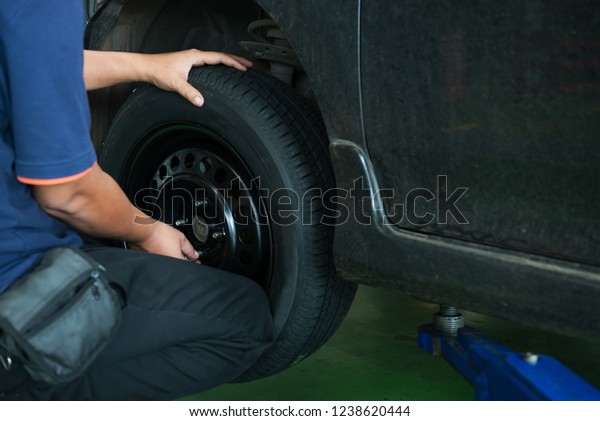 Technician change tire in the\
garage,According to the maintenance phase,Check problem of a\
car