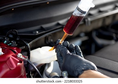 Technician changing brake fluid. Car maintenance concept. - Shutterstock ID 2218033325