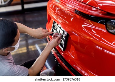 Technician Changing Car Plate Number In Service Center.