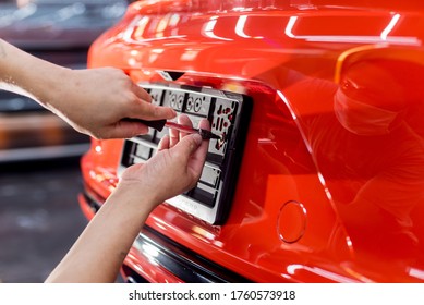 Technician changing car plate number in service center.