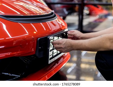Technician changing car plate number in service center.