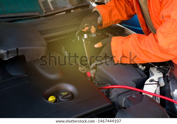 The
technician is changing the new battery for the
car.