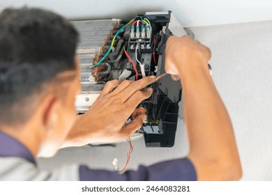 Technician checking air conditioning control board, Repairman fixed air conditioning systems, Technician man service repair and maintenance of air conditioners