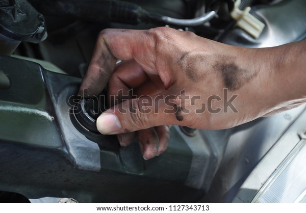 The\
technician is checking the car ,The hand is so\
dirty,