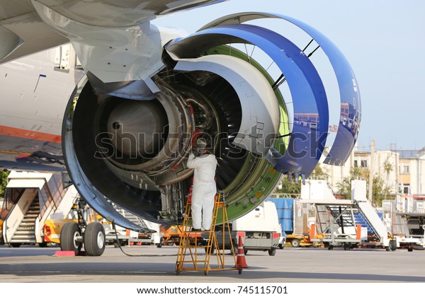 Technician checking\
engine of civil\
airliner.