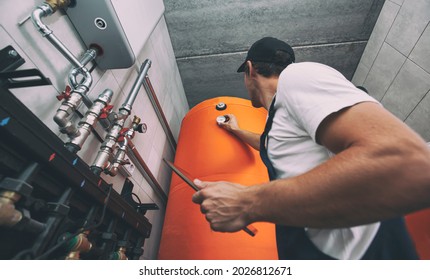 The technician checking the heating system in the boiler room with tablet in hand - Shutterstock ID 2026812671