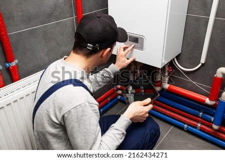 The technician checking the heating system in the boiler room with tablet in hand Stockfoto © 