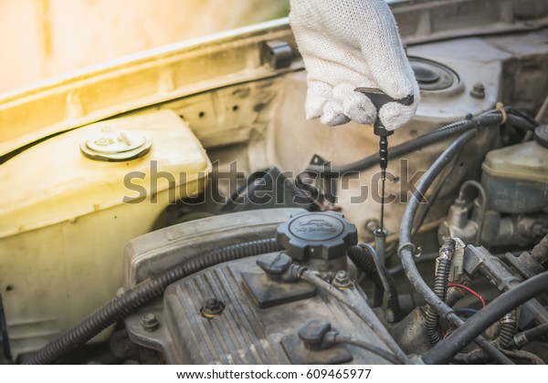 Technician checking level of engine oil of the car.\
Selective focus