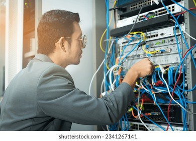 IT technician checking the network connection in server room for maintenance