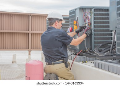 Technician checking for power on a rooftop condensing unit. 