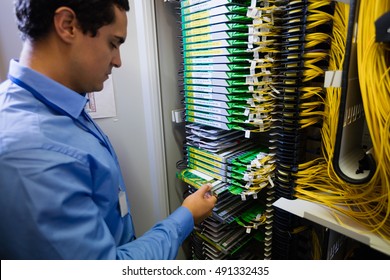 Technician checking routers in server room