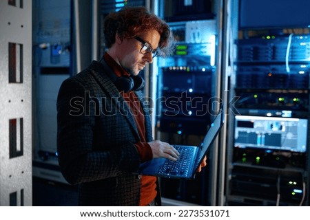 IT technician checking the servers vitals using laptop computer