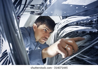 Technician is checking server's wires in data center