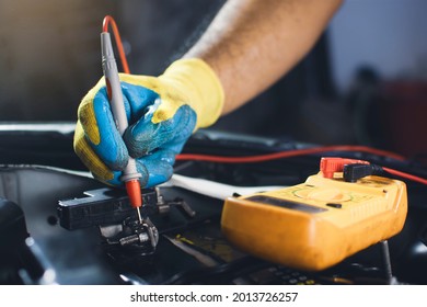 Technician To Checking Voltage Stable Of The Car Battery With Digital Multimeter Probe