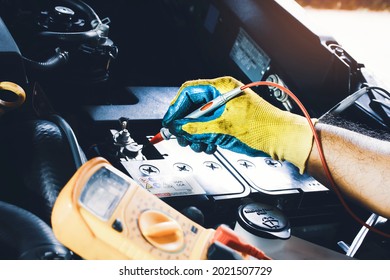 Technician To Checking Voltage Stable Of The Car Battery With Digital Multimeter Probe