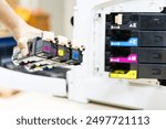 Technician choose ink cartridges of printer toner low to replace new and fix repair problem paper or print scanning fax or copy document or photocopier or photocopy office workplace equipment concept