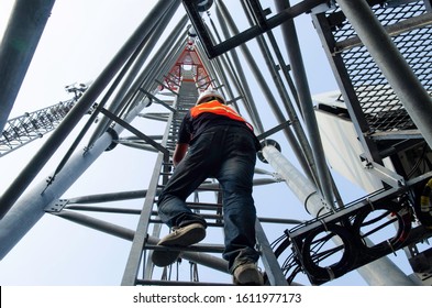 Technician Climb Ladder For Working On High Telecommunication Tower,worker Wear Personal Protection Equipment For Working High Risk Work,maintenance Equipment On High Tower.