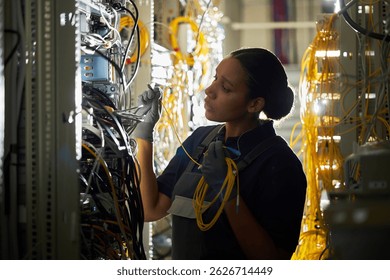 Technician Configuring Network Cables in Server Room
