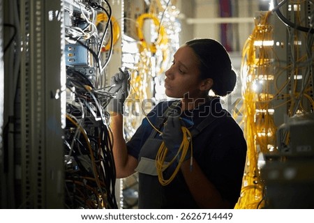 Technician Configuring Network Cables in Server Room