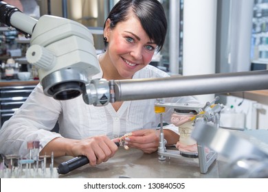Technician In Dental Lab Working Under A Microscope