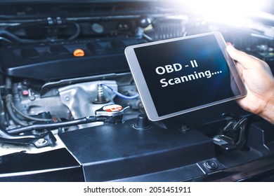 Technician diagnostics of code failure with OBD2 scanner technology on tablet in the auto repair garage