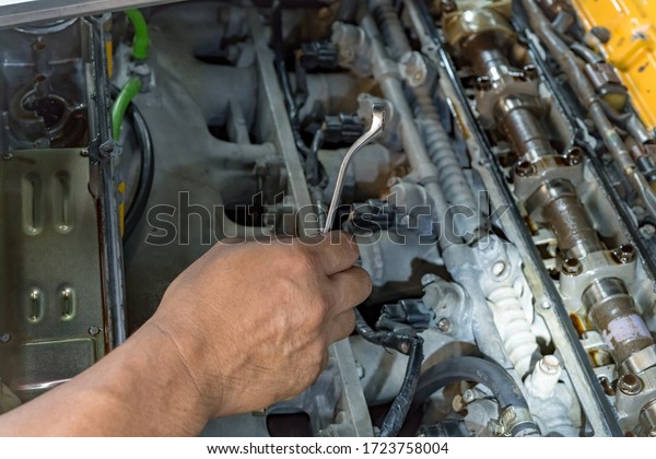 Technician doing the repair machine of a car in\
the house.