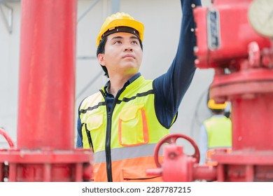Technician engineer checking controls system for security functions at factory,The engineer is inspecting the safety equipment on the fire extinguishing system.