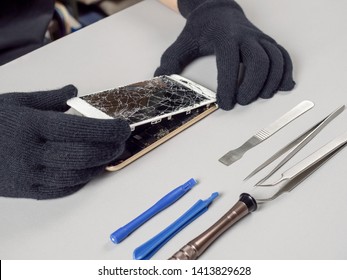 Technician or engineer opening broken smartphone for repair or replace new part on desk