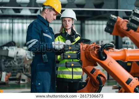 Technician Engineer Operating Robotic Arm in Factory, Automation and Advanced Technology to Enhance Production Control in Manufacturing Industry, Driving Innovation and Efficient Machine Work