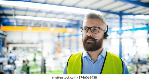 Technician or engineer with protective mask and headset working in industrial factory. - Powered by Shutterstock