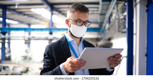 Technician Or Engineer With Protective Mask And Tablet Working In Industrial Factory.