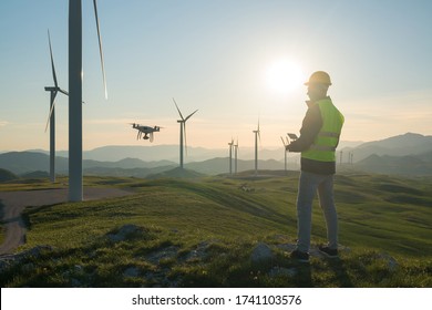 Technician Engineer in Wind Turbine Power Generator Station launches a drone for visual control of generators