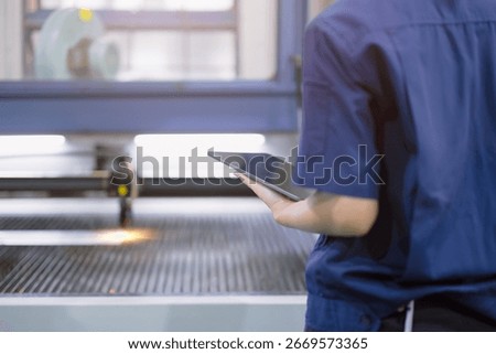 technician engineer worker Control operate Metal Laser cutting machine in modern steel heavy industry factory