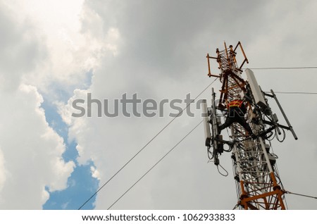 technician or engineer working on high telecommunication tower,blue sky and cloudy background. High Risk working.