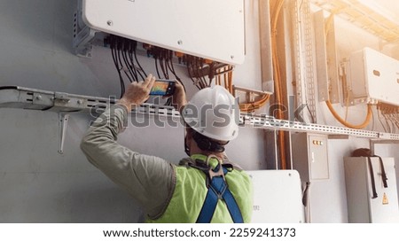 Technician Engineering   use thermal imaging camera to check temperature of instalation inverter solar panel in factory

