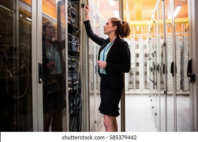 Technician examining server in server room - Powered by Shutterstock