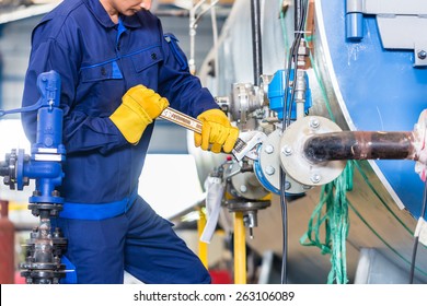 Technician In Factory At Machine Maintenance Working With Wrench